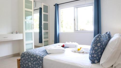 a room with a bed with towels and a window at Maison Marie Jeanne - Unit 1 in Baie Sainte Anne