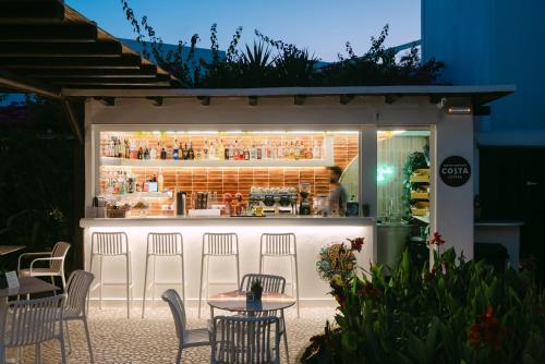 a bar with chairs and tables in front of it at Eleni Rooms in Parikia