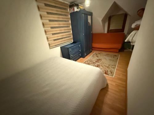 a bedroom with a bed and an orange chair at Ranc Cika Zlaje in Vitez