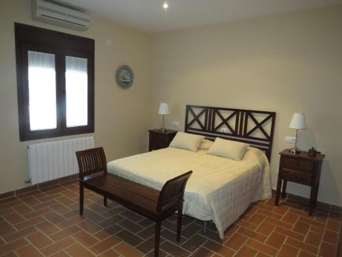 1 dormitorio con 1 cama, 1 silla y 1 ventana en Sol de Balbaina, en El Puerto de Santa María
