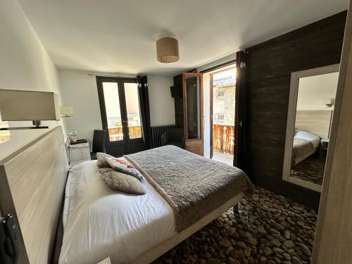 a bedroom with a bed and a large mirror at Hôtel-Chalet les Mélèzes in Valloire