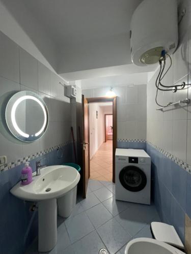 une salle de bain avec un lavabo et une machine à laver dans l'établissement Reys Central Orikum 2-Bedroom Apartment for Five, à Polisi i Vogël