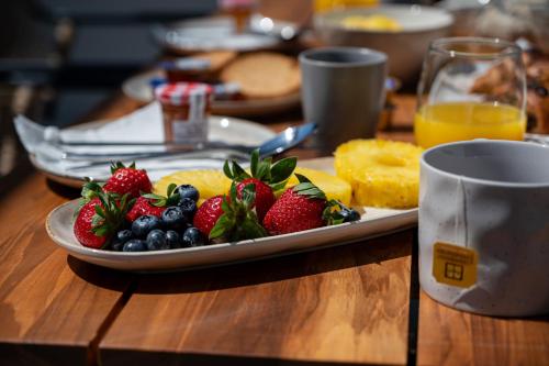 a plate of fruit on a table with a cup at Neutral Haven in Nafplio
