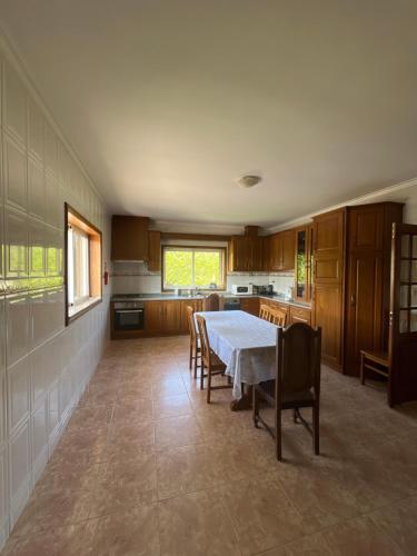a large kitchen with a table and chairs in it at Casa do Senhor da Ponte in Gondifelos