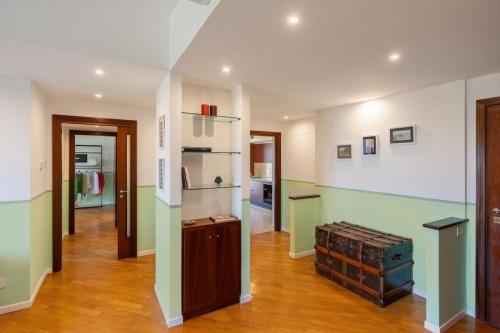 a living room with green and white walls and wooden floors at Sorrento Coast Retreat for Families with Terrace&View in Sant'Agnello