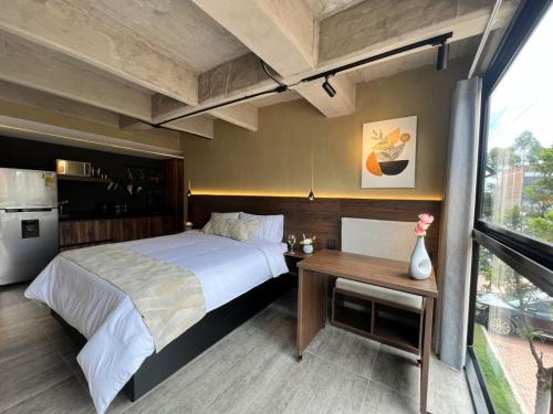 a bedroom with a large bed and a table at Mali Experience in Rionegro