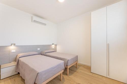 two beds in a room with white walls at Camping Europa in Capoliveri