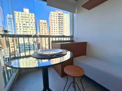 a table and stool in a room with a window at BHomy Medeiros in Sao Paulo