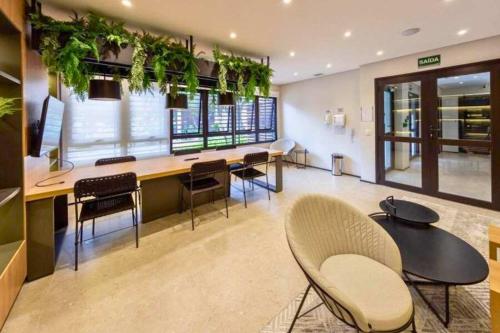 a room with chairs and a counter with plants at BHomy Medeiros in Sao Paulo