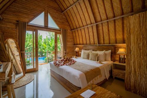 a bedroom with a large bed in a wooden room at Penida Green Palm Cottage by Bali Cabin in Toyapakeh