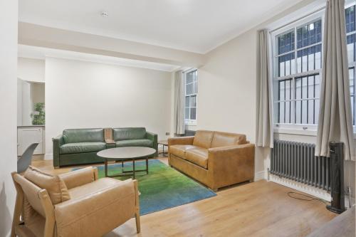 a living room with a couch and chairs and a table at BeiRoom Hyde Park Apartments in London