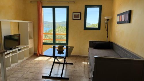 a living room with a couch and a television at Les Haut Du Lac in Sainte-Croix-de-Verdon