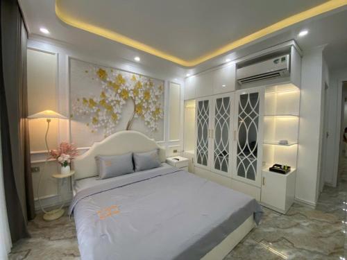 a bedroom with a white bed and a painting on the wall at Happy House in Cat Ba