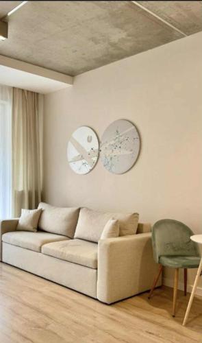 a living room with a couch and two mirrors on the wall at Airport Apartment Okęcie in Warsaw