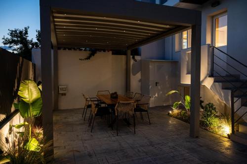 a patio with a table and chairs under a pergola at Neutral Haven in Nafplio