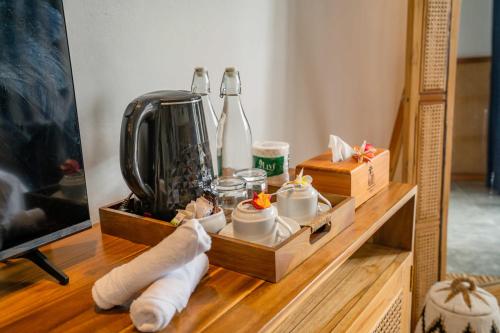 a table with a shelf with a bunch of items on it at Penida Green Palm Cottage by Bali Cabin in Toyapakeh
