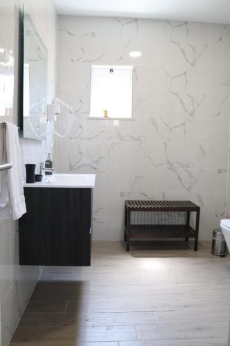 a white bathroom with a sink and a mirror at Curtido House Suits in Ílhavo