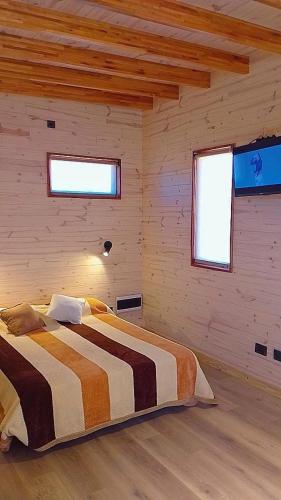 a bedroom with a bed in a wooden room at CJ cardones in Cafayate