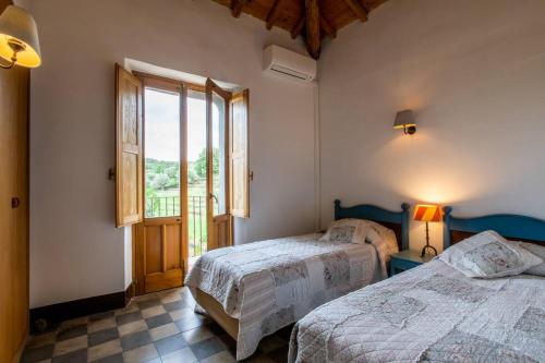 a bedroom with two beds and a large window at Tenuta Madonnina in Castiglione di Sicilia