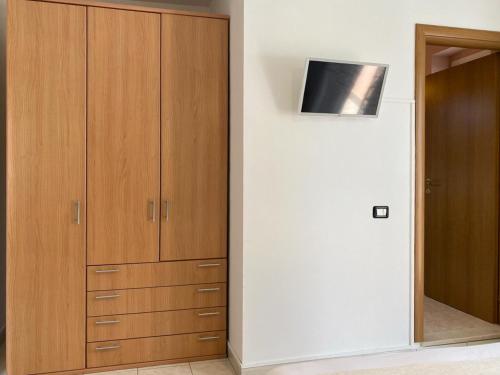 a closet with wooden cabinets and a television on a wall at La Farfalla in Fossacesia