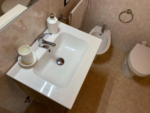 a bathroom with a white sink and a toilet at La Farfalla in Fossacesia