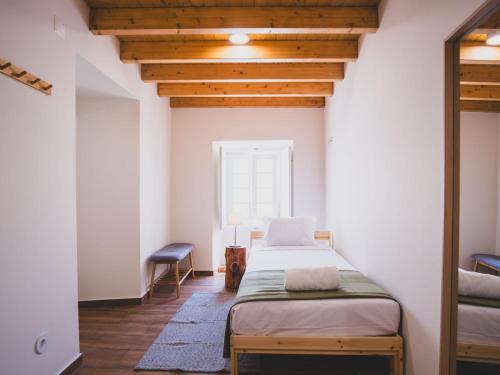 a bedroom with a bed and a chair in it at Casa p'ra Muralha in Óbidos