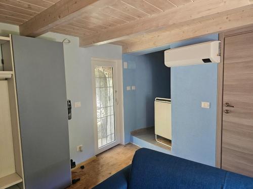 a living room with a blue couch and a window at La casetta in collina albissola in Stella