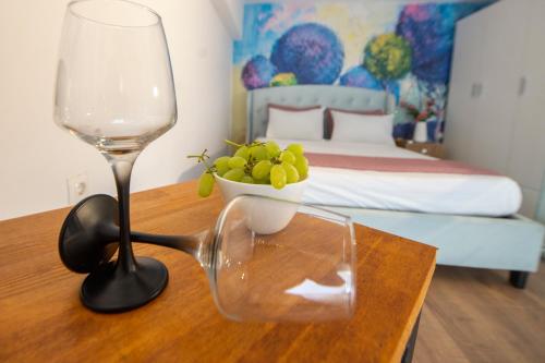 a table with a wine glass and a bowl of grapes at bella Kerkyra in Agios Rokkos
