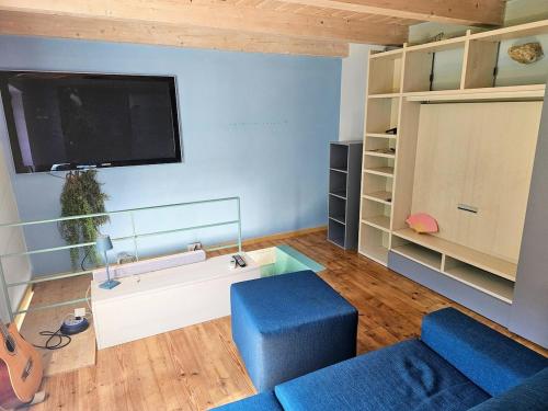 a living room with a blue couch and a tv at La casetta in collina albissola in Stella