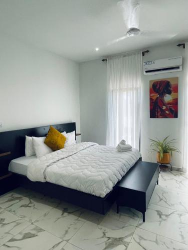 a bedroom with a large bed in front of a window at Platinum Blue Island Resort in Atimpoko