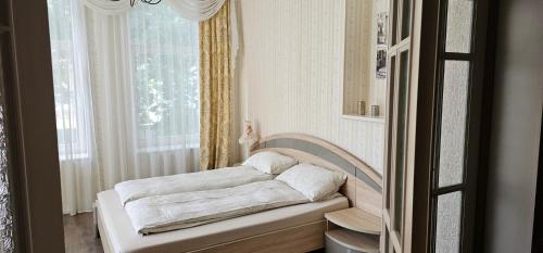 a white bed in a room with a window at Summer in Riga