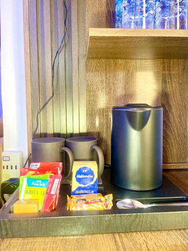 a shelf with a coffee pot and other food items at Morgan Hill Residence in Abuja