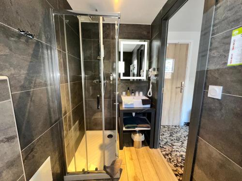 a bathroom with a shower and a sink at Hôtel-Chalet les Mélèzes in Valloire