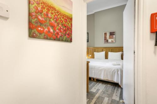 a room with a bed and a painting on the wall at BeiRoom Hyde Park Apartments in London