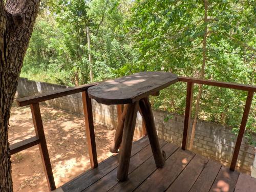 a wooden bench sitting on a wooden deck at Tree Nest Sigiriya in Kibissa