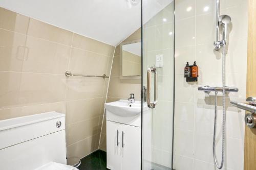 a bathroom with a shower and a toilet and a sink at BeiRoom Hyde Park Apartments in London