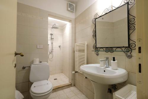Un baño con inodoro, lavabo y espejo. en Wine Apartments Florence Sagrantino, en Florencia
