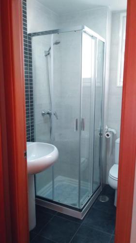 a bathroom with a glass shower and a sink at Piso Encanto Palmeiro in Jove