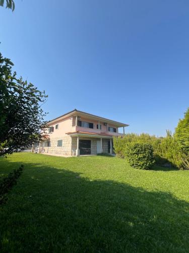 a large house on a grassy field with trees at Casa do Senhor da Ponte in Gondifelos