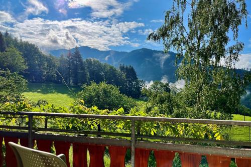a balcony with a view of a field and mountains at Steinweiden in Simonswald