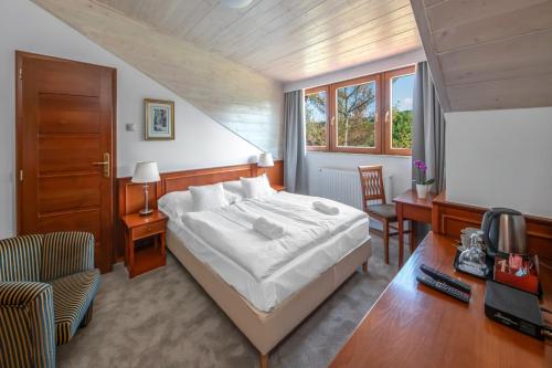 a bedroom with a bed and a desk and a chair at Bakony Resort - a Felnőttbarát Hotel - Szarvaskút Vendégpark in Zirc