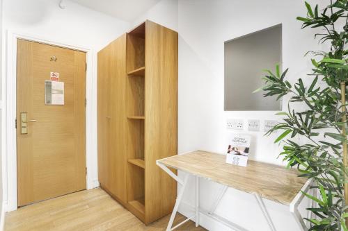 a room with a wooden desk and a door at BeiRoom Hyde Park Apartments in London
