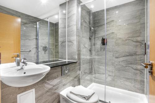 a bathroom with a sink and a toilet and a shower at BeiRoom Hyde Park Apartments in London