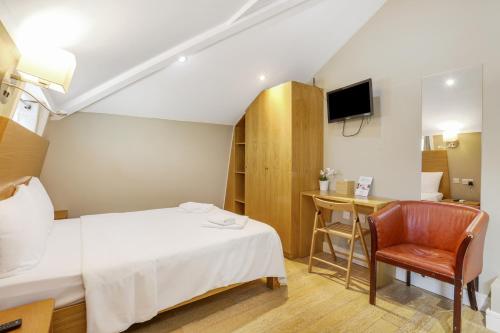 a bedroom with a bed and a chair and a desk at BeiRoom Hyde Park Apartments in London