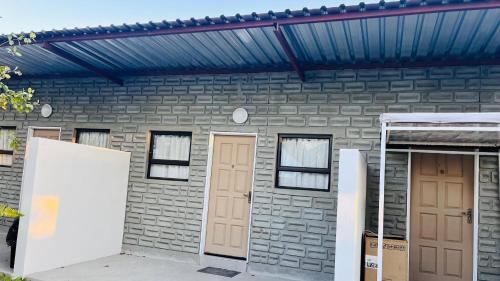 a brick house with two doors and a blue roof at Happy Forest B&B in Katima Mulilo