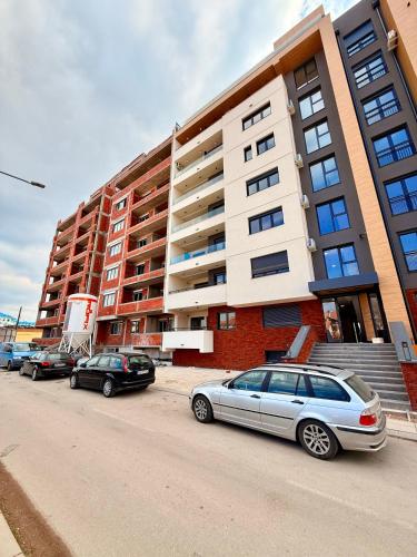 a row of cars parked in front of a building at Royal Apartmani 2 in Paraćin