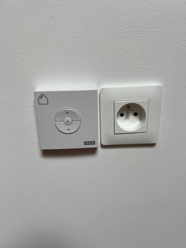 a white lightswitch on a wall in a room at La cabane in Aubigny-sur-Nère