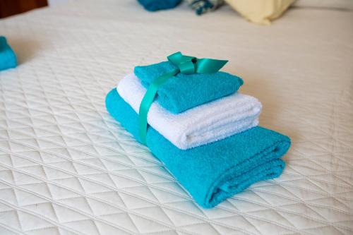 a stack of towels sitting on a bed at Mia guesthouse in Cefalù