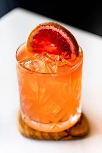 a drink with a grapefruit slice on top of it at Hotel Lulu in Round Top