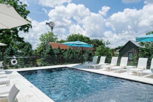 a swimming pool with chairs and umbrellas at Hotel Lulu in Round Top